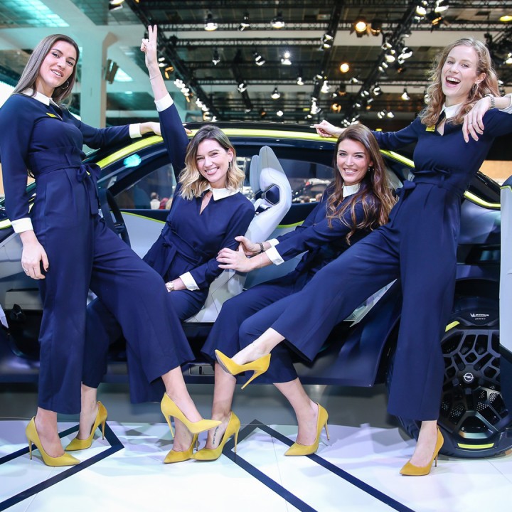 Hostesses in front of a car